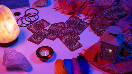 Tarot cards scattered on the table in a mystical setting. Cyberpunk blue pink neon light....