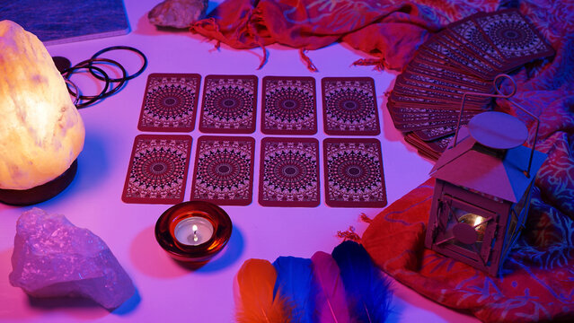 Tarot cards lined up in a mystical setting. Cyberpunk blue pink neon light. Predicting the future, esoteric, mystic.