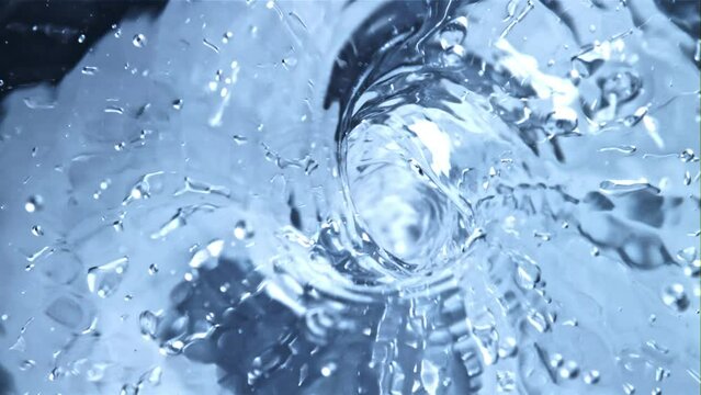 A whirlpool of water with air bubbles. Top view. Macro background.Filmed is slow motion 1000 fps.