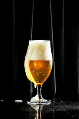 Beer. Cold Craft light Beer in a glass with water drops. Pint of Beer into a tall glass with a thick foam