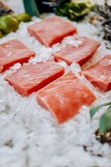 Chilled steaks of red fish. Pieces of fish lie on ice. Freezer shop window