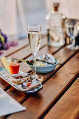 Fresh open oysters with a glass of chilled prosecco wine and set of shoot alcoholic cocktails served on table. Seafood delicios