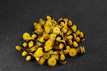 Macro photography of plastic yellow clips for a car on a gray background. Car clips, plastic fasteners.Yellow plastic clips on a gray background close-up.Car clips and fasteners.