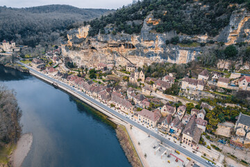 Fototapeta premium Aerial view of an ancient medieval French village along the river and mountain cliff, La Roque-Gageac, France