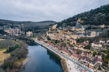 Fototapeta premium Aerial view of an ancient medieval French village along the river and mountain cliff, La Roque-Gageac, France