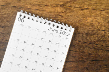 June 2022 desk calendar on wooden background.