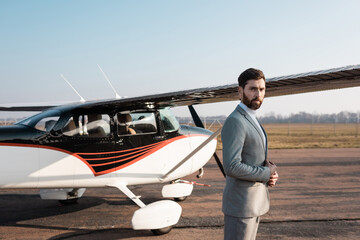 successful businessman in suit standing near helicopter outdoors.