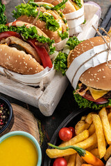Hamburgers and French fries on the wooden tray. Traditional American fast food. vertical image. top view