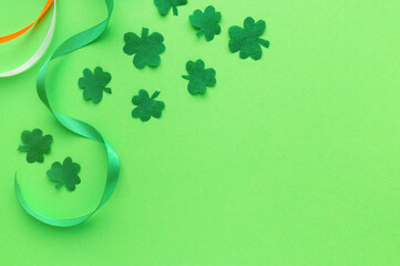 Greeting card for saint Patrick's day. Paper clover leaves with ribbons on green background,...