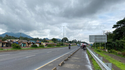 On the streets of Arusha. Green hills, roads, houses and transport of Tanzania.