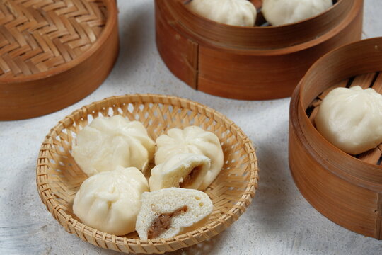 bao zi or bapao,bakpao-Chinese steamed buns,served in bamboo steamer.white background 