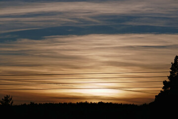 power lines, trees and sunset and orange sky in tyrol