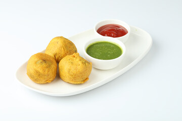 Indian snack aloo vada or bonda made from potato with coconut chutney. Indian snacks Aloo Bonda vada, pakoda, pakora.Paneer bonda indian snack, Served with tomato sauce placed 