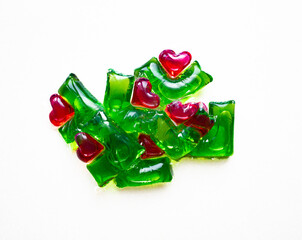 Washing capsules on a white background. Liquid laundry detergent in red-green heart-shaped capsules.