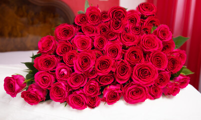 Many red roses lie on the bed. Bouquet of flowers 