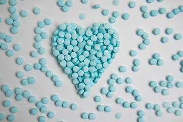 Obraz premium Heart made of blue pills isolated on white background 