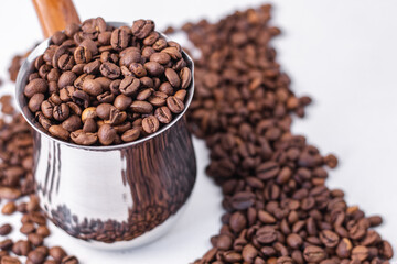 fragrant coffee beans stand on a white background in an iron coffee maker
