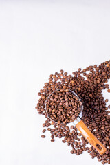 fragrant grains of medium roast coffee in a coffee maker on a white background