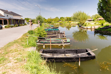 Marais au coeur d'une ville, barques à fond plat amarrées le long d'un canal avec un restaurant...