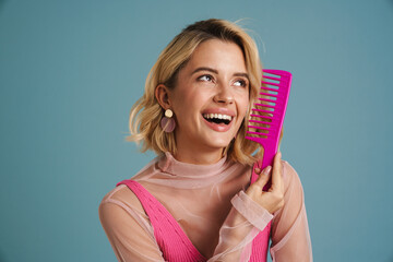 Young white woman smiling while combing her blonde hair