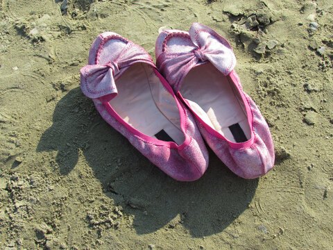 pink shoes on a sandy beach