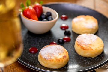 cheesecakes with berries on a plate garnished with jam. healthy breakfast.