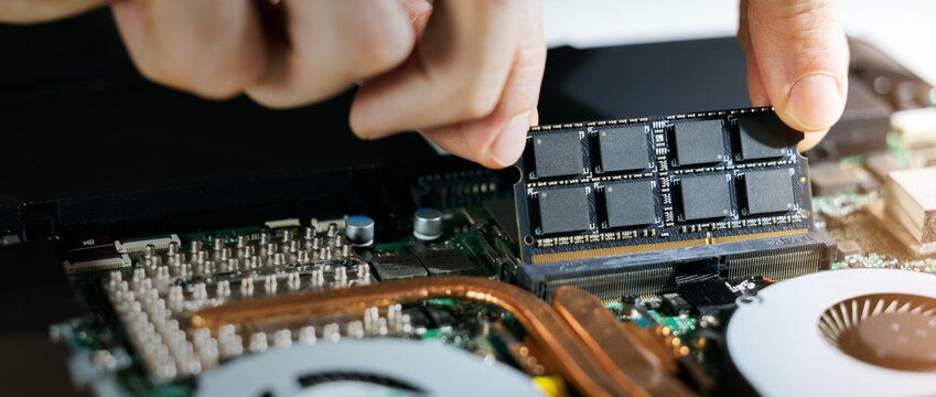 technician installing ram memory module in laptop motherboard. computer hardware upgrade. copy space