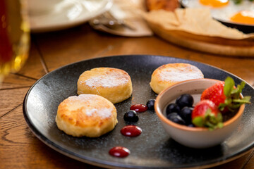 cheesecakes with berries on a plate garnished with jam. healthy breakfast.