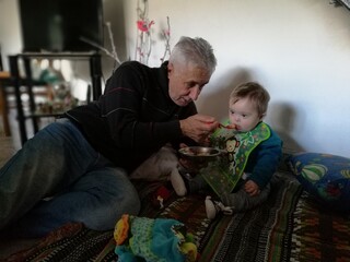 Abuelo le da de comer a nieto tirados en el piso con una cuchara sindrome dawn