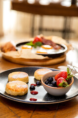 cheesecakes with berries on a plate garnished with jam. healthy breakfast.