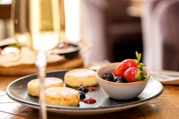 cheesecakes with berries on a plate garnished with jam. healthy breakfast.