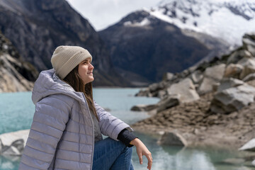 Young woman sitting while gazing at a picturesque landscape with a lake