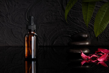 Mock-up of glass bottle with dropper. Brown container for skin care bottles on black background....