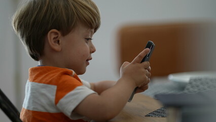 Child using phone small boy holding smartphone