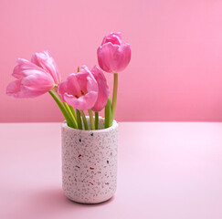 gentle spring background in pink with vase and tulips