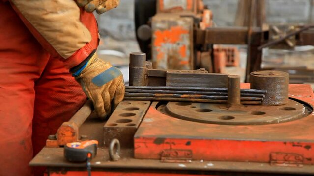 A man on bending machine makes blanks from a metal. Metal frame blanks