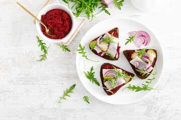 Sandwiches with salted herring fillet and beetroot pate. Top view, overhead