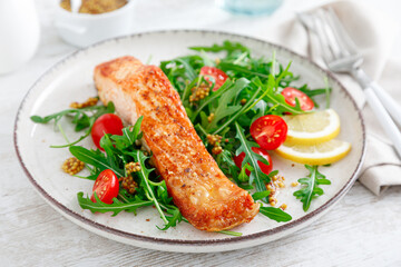 Salmon fish fillet grilled and fresh vegetable tomato salad with arugula. Healthy food. Ketogenic...