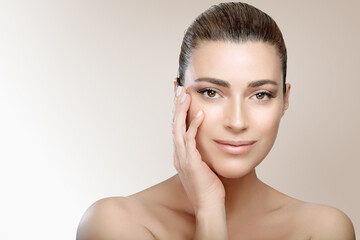 Beautiful brunette woman with clean fresh skin touch own face looking at camera. Beauty skin care and spa concept