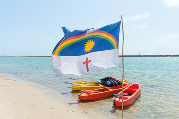 Pernambuco state flag waving with the wind at Muro Alto beach, a famous beach of Porto de Galinhas, Ipojuca city, Brazil. Beach tourist destination on the northeast coast.