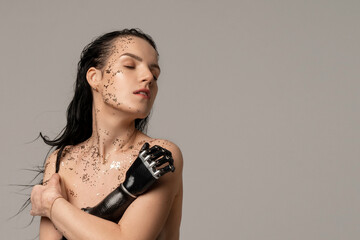 Beauty portrait Woman with artificial hand. Natural Clean Skin Nature Makeup with glitter Fresh Spa Women's Beautiful Cosmetic Portrait. Beauty variety. Isolated on beige background. Copy space