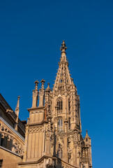 Fototapeta na wymiar The ornate gothic bell tower of Bern Minster against a blue sky, Switzerland.