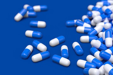 blue and white pharmaceuticals capsules 3D computer generated isolated on blue background