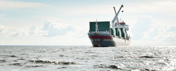 Large modern general cargo crane ship (142 meters length) sailing in an open sea. Freight...