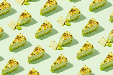 Creative pattern made of piece of pistachio cheesecake on green pastel background. Healthy dessert concept. Minimal style