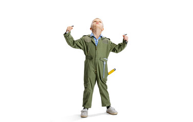 Portrait of little boy, cute kid in image of auto mechanic or fitter in green dungarees with work tools isolated over white studio background. Childhood, education concept