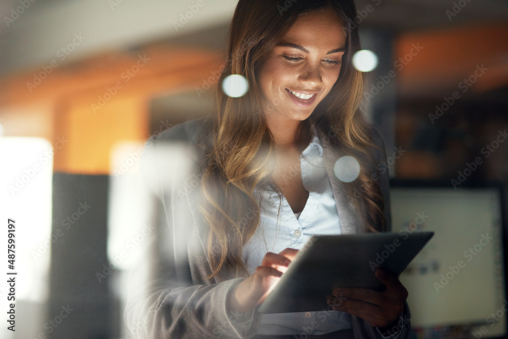 Canvas Prints Working hard no matter the time. Shot of a young attractive businesswoman working late at night in a modern office.