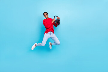 Fototapeta na wymiar Photo of cheerful emotion casual wear jumping girl take driving lesson hold steering wheel isolated on blue color background