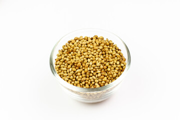 Coriander seeds on transparent glass bowl isolated on white background. Coriander seeds are a food ingredient and medicinal herbs.