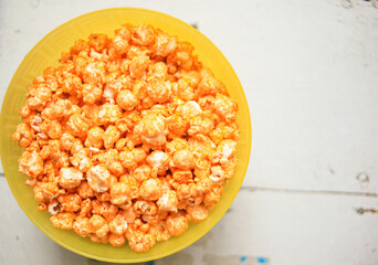 A plate of sweet popcorn on an old white table